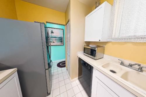 a small kitchen with a sink and a refrigerator at Kingston Arms On Lido Key, 1BR in Sarasota