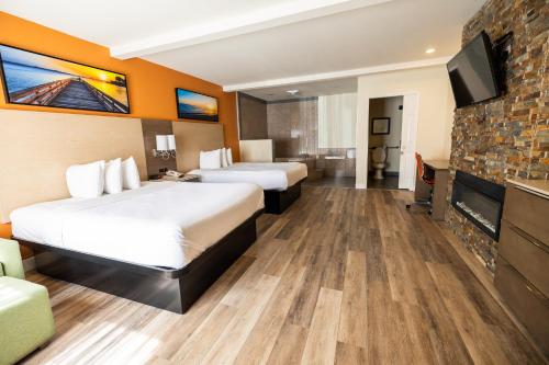 a hotel room with two beds and a flat screen tv at Days Inn by Wyndham Monterey Downtown in Monterey
