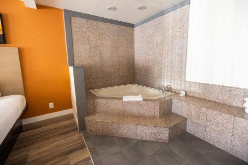een badkamer met een bad in de hoek van een kamer bij Days Inn by Wyndham Monterey Downtown in Monterey