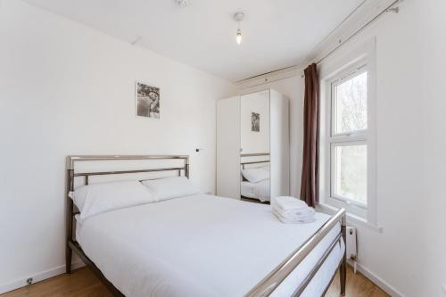 a white bedroom with a large bed and a window at Mile End Double Rooms 27 Guest house in London