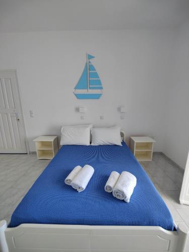 a bedroom with a blue bed with two towels at Kleanthi Apartments in Drios