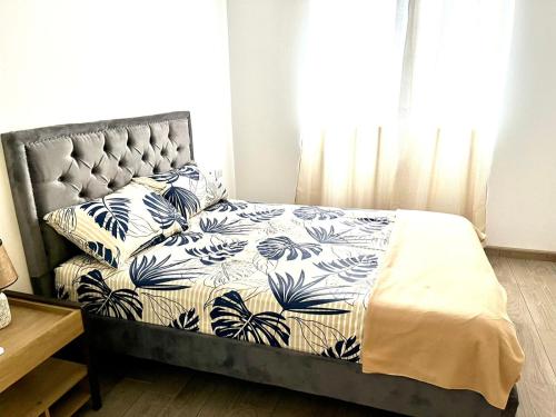 a bedroom with a bed with a blue and white comforter at Mar y Tierra in Manta