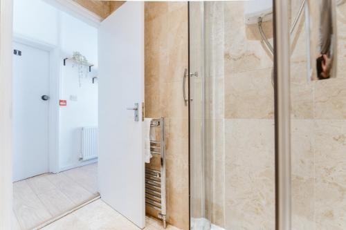 a bathroom with a shower with a glass door at Mile End Double Rooms 27 Guest house in London