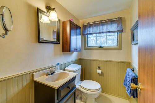 a bathroom with a toilet and a sink and a mirror at Sodus Point Vacation Rental Steps to Lake Ontario in Sodus