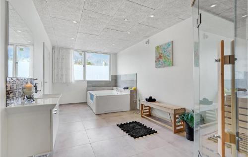 uma casa de banho branca com uma banheira e um lavatório em 5 Bedroom Amazing Home In Herning em Herning