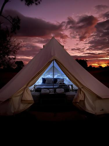 a white tent with a sunset in the background at Mungo Lodge in Mungo