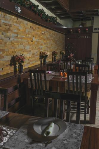 a restaurant with wooden tables and chairs and a brick wall at Garni Hotel City in Kruševac