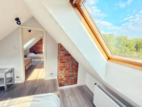 a attic bedroom with a window and a brick wall at Urban Jungle - luksusowy apartment w Gdyni. in Gdynia