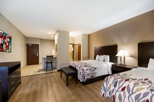 a hotel room with two beds and a desk at Red Roof Inn Pecos in Pecos