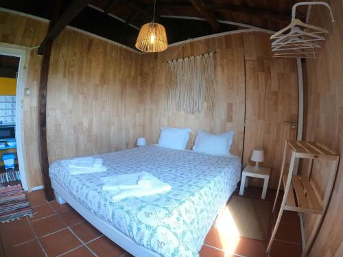 a bedroom with a bed with towels on it at Casa dos Flamingos in Murtosa