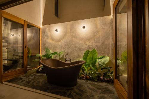baño con bañera y algunas plantas en Casa Mava en Brisas de Zicatela