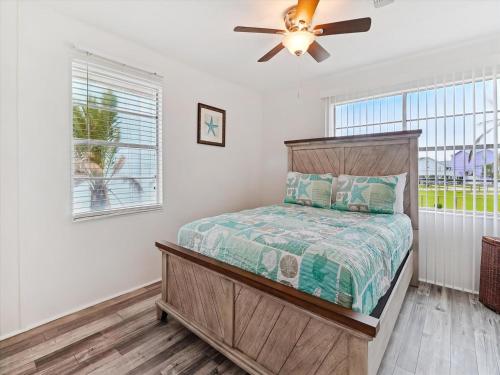 a bedroom with a bed and a ceiling fan at Peggys Hideaway in Galveston