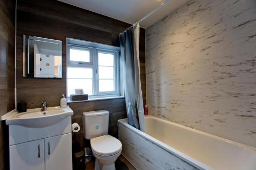 a bathroom with a toilet and a sink and a tub at Marvelous Flat in Earls Court - London in London