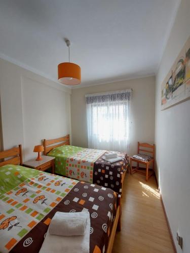 a bedroom with two twin beds and a window at Coluna Mar in Quarteira