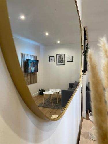 ein Spiegel mit einem Wohnzimmer mit einem Tisch und einem Sofa in der Unterkunft Le cocon Lorientais à 5 min à pied de la gare in Lorient
