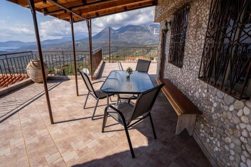 a patio with a table and chairs on a balcony at Sea & Mountain Serenity in Plátsa