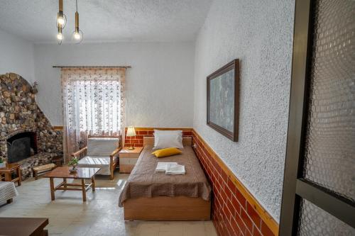 um quarto com uma cama e uma sala de estar com lareira em Sea & Mountain Serenity em Plátsa