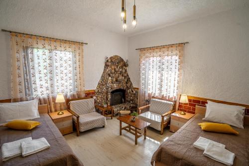 a living room with two beds and a fireplace at Sea & Mountain Serenity in Plátsa