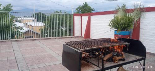 una parrilla de barbacoa en un patio junto a una valla en "C" SPACIO HOSTEL - Habitación Compartida- en Mendoza