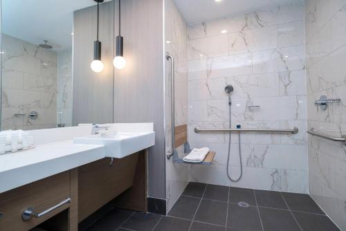 a bathroom with a sink and a shower at Sandman Signature Sherwood Park Hotel in Sherwood Park