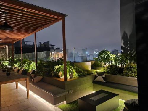 ¡Una escapada relajante en Lima! في ليما: شرفة مع نباتات الفخار على المبنى