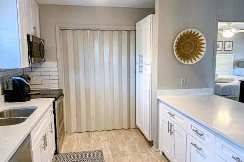 a kitchen with a sink and a door to a bedroom at Sea Pine Cottage in St. George Island