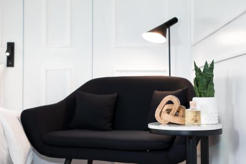a black couch sitting in a living room with a table at Hotel Tano Guam in Tumon