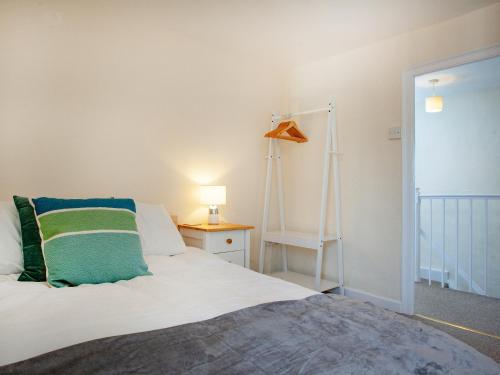 Un dormitorio con una cama con una almohada verde. en Bridgetown, en Totnes