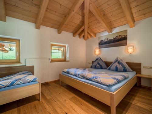 two beds in a room with wooden ceilings at Sommerstein in Maria Alm am Steinernen Meer