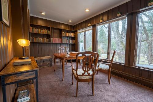 a dining room with a table and chairs and windows at Pump House Inn & Spa in Skytop