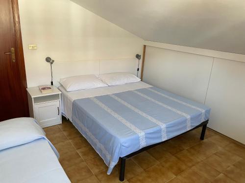 ピネートにあるUna mansarda al mareの小さなベッドルーム(ベッド1台、ナイトスタンド付)