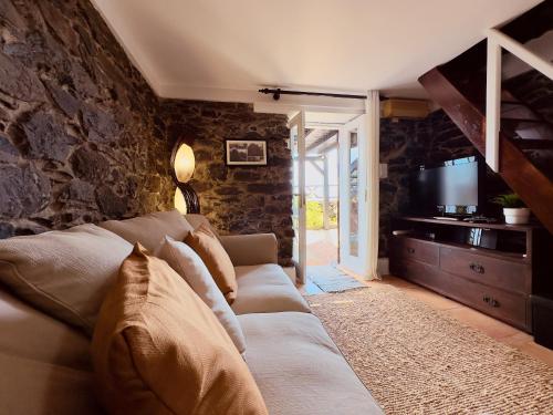 a living room with a couch and a television at Typical House -Madeira Inn Group in Calheta