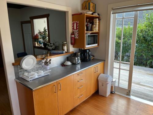 a kitchen with wooden cabinets and a counter top at Bayswater Homestay in Auckland