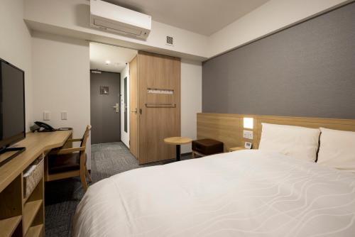 Postel nebo postele na pokoji v ubytování Dormy Inn Hiroshima Annex