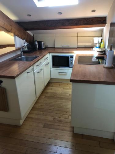 une cuisine avec des armoires blanches, un évier et un micro-ondes dans l'établissement appartement centre croisette emplacement exceptionnel, à Cannes