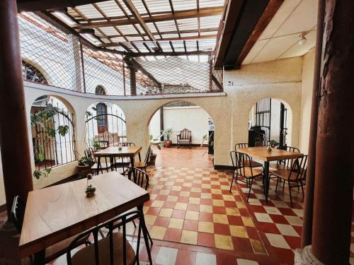 a restaurant with tables and chairs and a checkered floor at Anexo By Hotel Maya Ik' in Antigua Guatemala