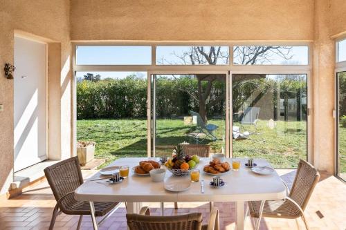 une table blanche avec un bol de fruits dessus dans l'établissement * Mas Jasmin *, à Vallauris