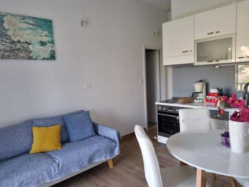 - un salon avec un canapé bleu et une table dans l'établissement Apartments with a parking space Postira, Brac - 727, à Postira