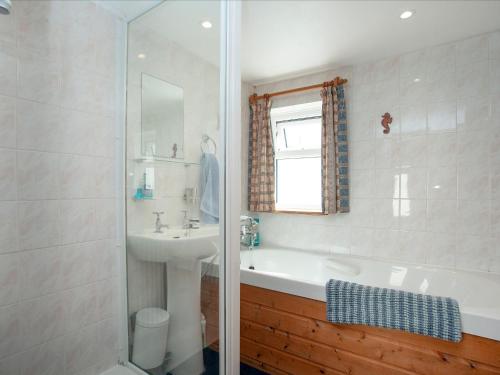 比迪福德的住宿－Summer Cottage，带浴缸、水槽和淋浴的浴室