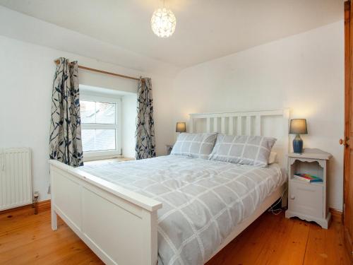 比迪福德的住宿－Summer Cottage，卧室配有白色的床和窗户。