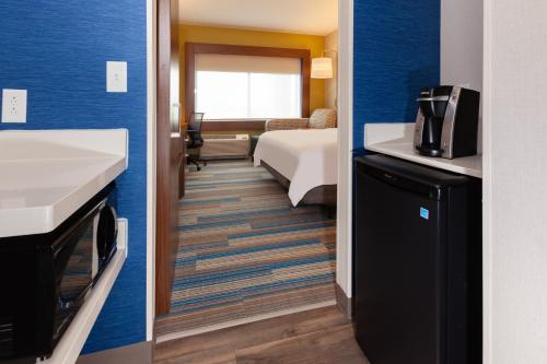 a hotel room with a bed and a bathroom at Holiday Inn Express & Suites Brunswick-Harpers Ferry Area by IHG in Brunswick