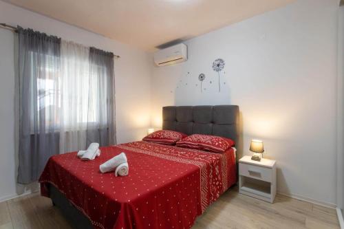 um quarto com uma cama vermelha com duas toalhas em Apartments with a parking space Kastel Novi, Kastela - 21085 em Kaštela