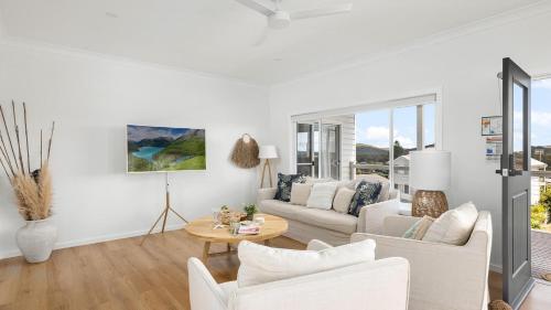 a living room with white furniture and a table at Soul Bliss at Shoal Bay in Shoal Bay