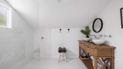 uma casa de banho branca com um lavatório e um espelho em Soul Bliss at Shoal Bay em Shoal Bay