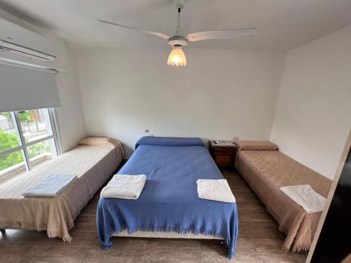 a bedroom with a blue bed and a couch at Departamentos Salvador in Termas de Río Hondo