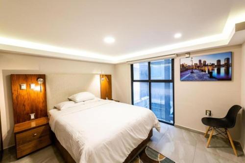 a bedroom with a white bed and a large window at Rochester 10 in Mexico City