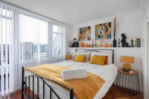 a bedroom with a large bed with yellow pillows at Hyde Park Rooftop Apartment in London