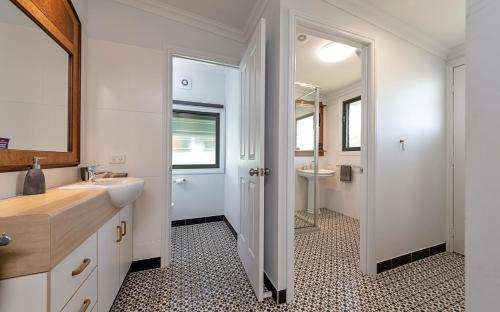 een witte badkamer met een wastafel en een spiegel bij Area51 Warwick in Warwick