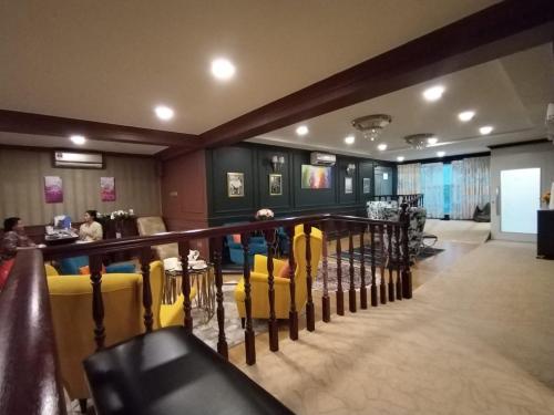 a restaurant with yellow chairs and a bar at Grand Illusyin in Shah Alam