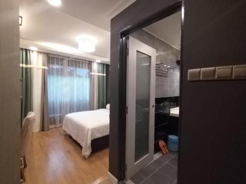 a bedroom with a bed and a bathroom with a mirror at Grand Illusyin in Shah Alam